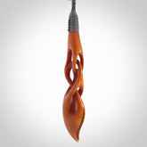 This necklace is carved from cow bone and stained with a homemade tea dye. It is a unique piece of wearable art that is sure to catch the eye. The shape is a complex twist form and has been beautifully hand carved by bone carver Yuri Terenyi.